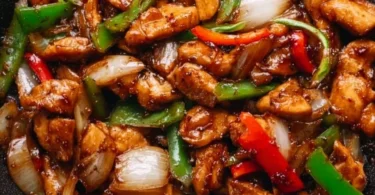 Delicious black pepper chicken served on a plate with vegetables