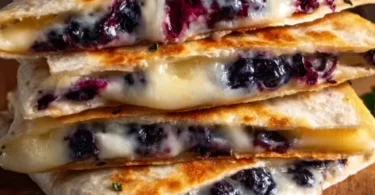 Blueberry breakfast quesadilla served on a plate with blueberries on the side