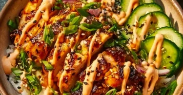 Crispy chicken with spicy sauce served over jasmine rice on a plate