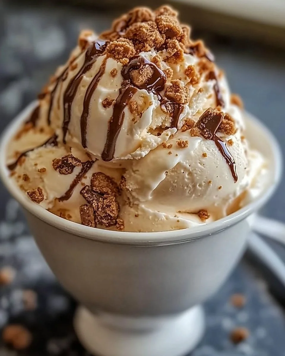 Scoop of malted milk toffee crunch ice cream in a cone with toffee bits
