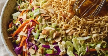A colorful bowl of crunchy ramen noodle salad with fresh vegetables