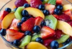 Delicious fruit salad drizzled with honey lime dressing in a bowl