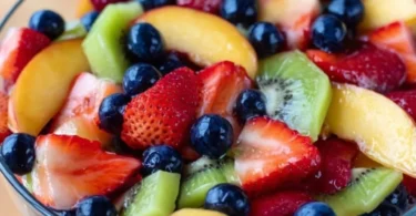 Delicious fruit salad drizzled with honey lime dressing in a bowl