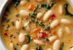 High protein white bean soup in a bowl garnished with herbs and spices.