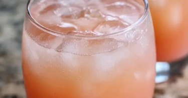 Iced Guava White Tea Lemonade in a glass with lemon garnish