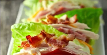 Low carb chicken club sandwich with lettuce, tomato, and bacon on whole grain bread