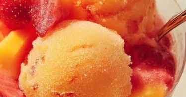 A bowl of vibrant Mango Strawberry Sorbet garnished with fresh fruit