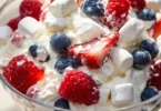 Red White and Blue Cheesecake Salad with fresh strawberries, blueberries, and creamy cheesecake topping