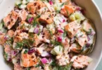 Colorful and fresh salmon salad with vegetables and dressing