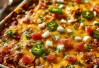 Delicious Taco Bake Casserole topped with cheese and salsa in a baking dish