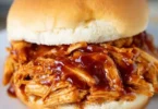 Delicious Crockpot BBQ Chicken served on a plate with BBQ sauce