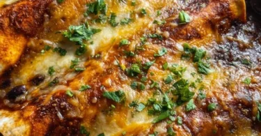 Delicious vegetarian black bean enchiladas topped with cheese and garnished with cilantro